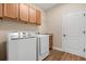 Convenient laundry room with granite counters, overhead cabinets, and modern machines at 4210 Arlington Ridge Blvd, Leesburg, FL 34748