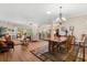 Open living and dining area with hardwood floors, chandelier and an archway into the kitchen at 4210 Arlington Ridge Blvd, Leesburg, FL 34748