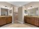 Bathroom with separate vanities, tiled floors, mirrors, and a walk-in shower at 4210 Arlington Ridge Blvd, Leesburg, FL 34748