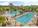Resort-style pool area featuring a lap pool, free-form pool, pergolas, lounge chairs and lush tropical landscaping at 4210 Arlington Ridge Blvd, Leesburg, FL 34748