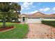 Beautiful home exterior featuring a brick driveway, two-car garage, and lush landscaping at 5071 Harbour Dr, Oxford, FL 34484
