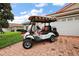 Charming home exterior with a brick driveway and a golf cart in the foreground at 5071 Harbour Dr, Oxford, FL 34484