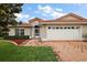 Well-maintained home with brick driveway, two-car garage and manicured landscaping at 5071 Harbour Dr, Oxford, FL 34484