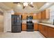 Functional kitchen with stainless steel refrigerator, black oven, and microwave with wooden cabinets at 5071 Harbour Dr, Oxford, FL 34484