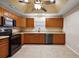 Well-equipped kitchen with stainless steel appliances, wooden cabinets, and a ceiling fan at 5071 Harbour Dr, Oxford, FL 34484