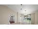 Living room featuring tile floors, high ceilings, sliding glass doors, and backyard view at 5071 Harbour Dr, Oxford, FL 34484