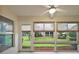 Bright sunroom with large windows offering a view of the manicured lawn and backyard at 5071 Harbour Dr, Oxford, FL 34484