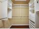 Walk-in closet with custom shelving and wood floors at 5071 Harbour Dr, Oxford, FL 34484