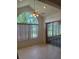 Light-filled dining space with large arched window, ceiling fan, and sliding glass doors to the sunroom at 5268 Sw 110Th Pl, Ocala, FL 34476