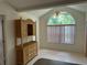 Bright dining area featuring a large arched window, ceiling fan, and a charming wicker china cabinet at 5268 Sw 110Th Pl, Ocala, FL 34476