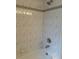 Bathtub and shower with decorative tile surround and shower head at 5268 Sw 110Th Pl, Ocala, FL 34476