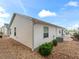 Charming home exterior with well-maintained landscaping, concrete patio, and a view of a blue sky at 5719 Spartina Ter, The Villages, FL 32163