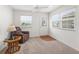 Bright living room showcasing a decorative glass front door, carpeted flooring, and natural light at 5719 Spartina Ter, The Villages, FL 32163