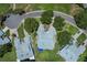 An overhead view showcasing a home's placement on a well-manicured street with mature trees and landscaping at 6036 Topsail Rd, Lady Lake, FL 32159