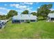 Aerial view of home's backyard, showcasing lush green lawn and manicured landscaping at 6036 Topsail Rd, Lady Lake, FL 32159