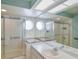 Unique bathroom featuring a glass enclosed shower and bathtub combination with a vanity area and ample lighting at 6036 Topsail Rd, Lady Lake, FL 32159