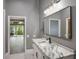Modern bathroom with a large vanity and a clear view to the outside through a large sliding glass door at 6036 Topsail Rd, Lady Lake, FL 32159