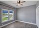Bedroom features a ceiling fan and natural light from a window with white shutters and wood-look vinyl floors at 6036 Topsail Rd, Lady Lake, FL 32159