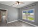 Bedroom features wood-look vinyl floors, a ceiling fan and natural light from a window with white shutters at 6036 Topsail Rd, Lady Lake, FL 32159