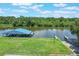 Lush aerial shot of a boat dock on the water with boat lift at 6036 Topsail Rd, Lady Lake, FL 32159