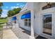 Inviting home entrance featuring a glass door, blue awnings, and wrought iron gate at 6036 Topsail Rd, Lady Lake, FL 32159