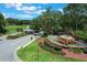 Aerial view of the community entrance with a gatehouse, fountain, and well-maintained landscaping at 6036 Topsail Rd, Lady Lake, FL 32159