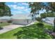 Charming home with a blue tile roof, well-maintained lawn, and inviting curb appeal under a sunny sky at 6036 Topsail Rd, Lady Lake, FL 32159