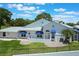 Charming single-story home featuring a white exterior, blue awnings, and a well-manicured lawn at 6036 Topsail Rd, Lady Lake, FL 32159