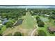 Aerial view showcasing a golf course featuring water hazards, tree-lined fairways and views of the lake at 6036 Topsail Rd, Lady Lake, FL 32159
