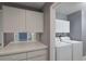 Laundry room with white cabinets and countertops with a newer washer and dryer at 6036 Topsail Rd, Lady Lake, FL 32159