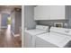 Laundry room with white cabinets, laminate floors, and newer washer and dryer at 6036 Topsail Rd, Lady Lake, FL 32159