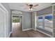 Living room featuring wood floors, ceiling fan, built-in shelves, and views through sliding glass doors at 6036 Topsail Rd, Lady Lake, FL 32159
