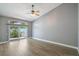 Spacious main bedroom featuring wood-look vinyl floors, a ceiling fan, and sliding glass doors at 6036 Topsail Rd, Lady Lake, FL 32159
