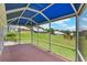 Screened-in lanai with blue sunshade, and views of a well-maintained green lawn at 6036 Topsail Rd, Lady Lake, FL 32159