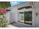 Bright patio with white textured walls, tile flooring, sliding glass doors and a vibrant flowering bush at 6036 Topsail Rd, Lady Lake, FL 32159