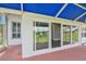 View of the screened lanai with blue sunshade looking in through sliding doors to the interior at 6036 Topsail Rd, Lady Lake, FL 32159