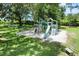 Community playground with slide and climbing structure nestled under mature trees at 6036 Topsail Rd, Lady Lake, FL 32159