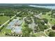 Aerial view of the tennis courts surrounded by lush landscaping and greenery near the golf course at 6036 Topsail Rd, Lady Lake, FL 32159