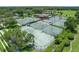 Aerial view of community tennis courts surrounded by trees and lush landscaping at 6036 Topsail Rd, Lady Lake, FL 32159