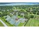 Aerial view of community tennis courts near a lake, surrounded by trees and green spaces at 6036 Topsail Rd, Lady Lake, FL 32159