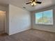 Cozy bedroom featuring plush carpeting, a ceiling fan, and a bright window at 624 Australian Way, Davenport, FL 33897