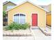 Charming yellow home with a red door and landscaped front yard at 624 Australian Way, Davenport, FL 33897
