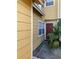 A yellow townhouse with white trim, a red front door, and lush tropical landscaping at 624 Australian Way, Davenport, FL 33897