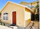 Inviting yellow house with a prominent red door, complemented by bright white trim and a 'hello' doormat at 624 Australian Way, Davenport, FL 33897