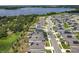 Aerial view of a residential community with houses, streets, green spaces and a large lake in the background at 6946 Perch Hammock Loop, Groveland, FL 34736