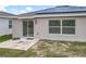 Backyard view featuring a concrete patio, sliding glass door, and solar panels on the roof at 6946 Perch Hammock Loop, Groveland, FL 34736