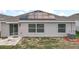 A view of the backyard with a concrete patio, windows, solar panels, and HVAC system at 6946 Perch Hammock Loop, Groveland, FL 34736
