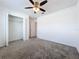 Neutral bedroom features plush carpet, ceiling fan and closet space at 6946 Perch Hammock Loop, Groveland, FL 34736