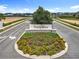 Well-manicured Trinity Lakes entrance with stone signage surrounded by colorful flowering plants at 6946 Perch Hammock Loop, Groveland, FL 34736