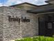 A stone entrance to Trinity Lakes with signage and a security gate at 6946 Perch Hammock Loop, Groveland, FL 34736